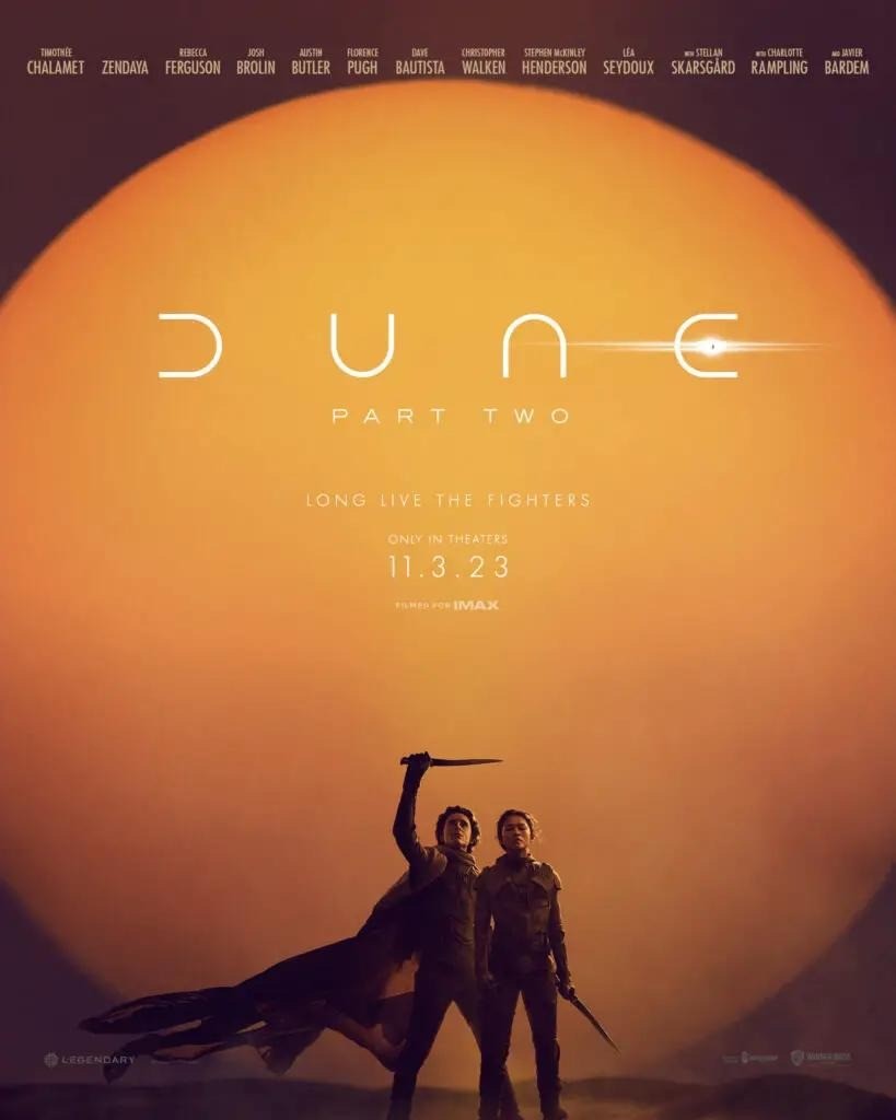 The poster for Dune 2: Paul Atreides and Chani, both clad in Fremen stillsuits and Paul wearing a cape, standing in front of the Arakeen sun. Both carry knifes: Chani keeping it lowered, Paul raising it above his head.